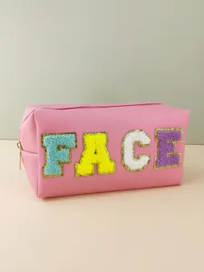 Detailed view of pink PU cosmetic bag with colorful chenille letter patches and zipper closure.