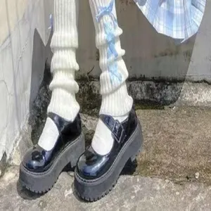 Detailaufnahme der süßen japanischen JK Strick-Beinwärmer mit blauen Schleifen und Schuhen.