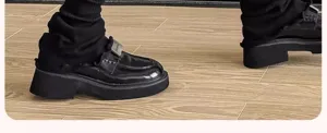 Mocassins compensés noirs associés à des jambières en tricot, détail de chaussures.