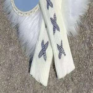 Weisse gestrickte Beinaermer Detail mit suessen blauen Karo Band Schleifen fuer den Winter Look.