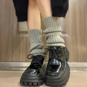 Grey knitted leg warmers for women, cozy winter slouch socks, stylish aesthetic footwear accessory.