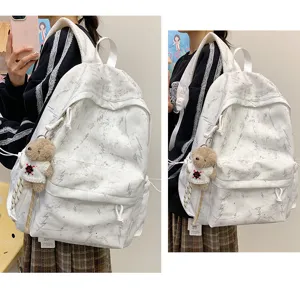 White aesthetic backpack with lightning pattern and cute plush bear charm detail