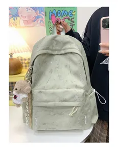 Detailed view of artistic light green student backpack with lightning pattern and charm