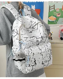 Gros plan de la vue arrière d'un sac à dos scolaire en nylon blanc avec motif craquelé noir