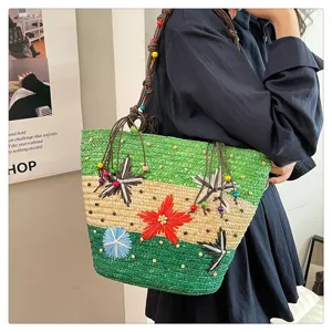 Detailed view of multi-color woven straw tote bag with floral accents and beaded straps