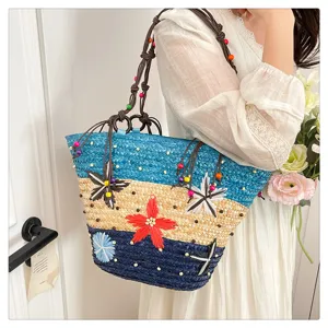 Detailed view of multi-color woven straw tote bag with vibrant flower accents and beaded straps