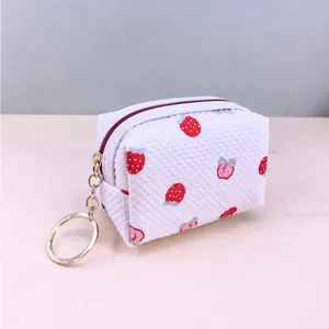 Detail view of the white waffle coin pouch featuring cute red strawberry prints and keyring.