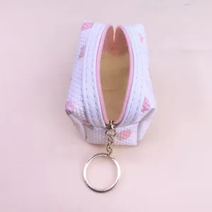 Detailed view of a cute mini waffle coin purse with strawberry print and pink zipper.