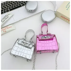 Detailed view of trendy laser stone pattern mini Kelly style handbags in silver and pink colors.