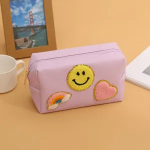 Cute purple cosmetic bag with embroidered smiley face, heart and rainbow patches for women daily use.
