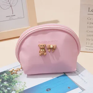 Pink semi-circular coin pouch detail with cute teddy bear and bow decoration for daily use.