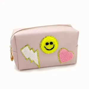 Pink cosmetic bag with chenille smiley face patch, stylish travel makeup pouch for women.