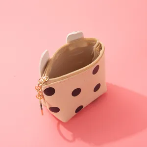 Detailed view of cute polka dot coin purse with bunny ears and zipper closure, soft pink.