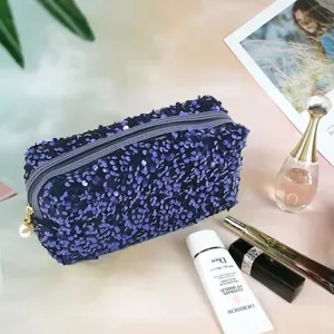 Detailed view of sparkling sequined cosmetic bag in a chic setup with beauty props.