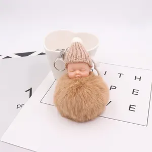 Nahaufnahme des süßen schlafenden Baby Plüsch Schlüsselanhängers mit weichem Pompom und Mütze.