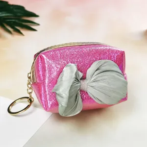 Detailed close-up of a gradient laser pink coin purse featuring a large grey satin bow and ring.
