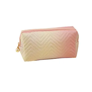 Gradient cosmetic bag with chevron quilting and elegant pearl zipper pull for daily makeup storage.
