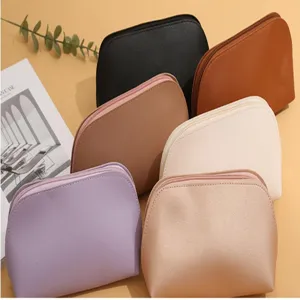 Detail shot of solid color leather cosmetic pouch, portable shell makeup storage bag.