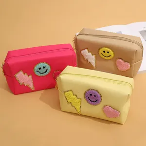 Detailed view of cute PU cosmetic bags set featuring fluffy smiley face patches and vibrant colors.