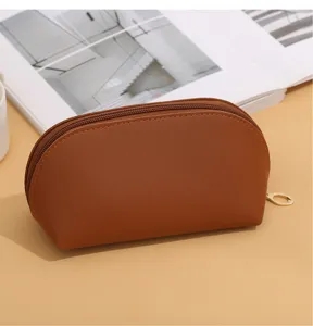 Brown leather cosmetic bag detail, showing smooth texture and durable zipper pull design.