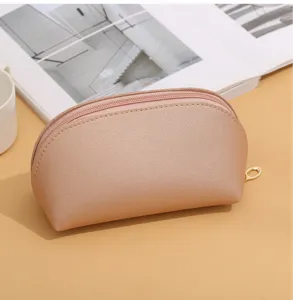 Detailed shot of the minimalist leather shell cosmetic bag, showing texture and zipper.