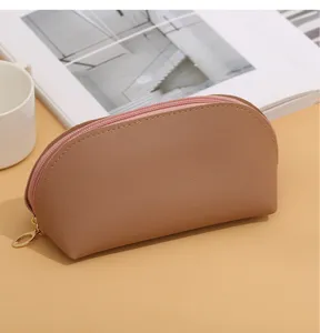 Minimalist PU leather cosmetic bag with zipper, portable shell makeup pouch for daily use.