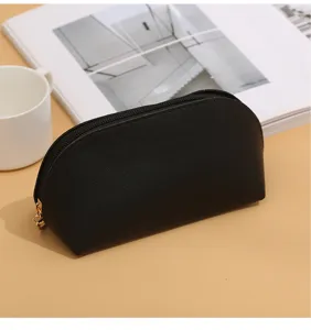 Minimalist black PU leather cosmetic bag with zipper, portable shell makeup pouch for travel.