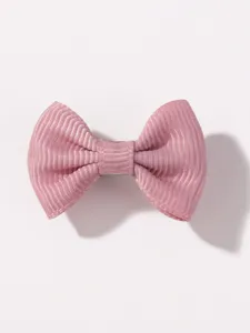 Detalle en primer plano del pasador de pelo con lazo rosa, diseño encantador y fino.