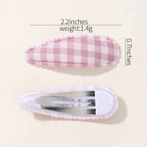 Close-up detail of pink gingham fabric BB hair clips with weight and size labels