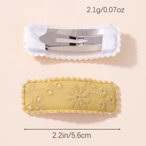 Detail view showing front and back of floral embroidered yellow hair clip with dimensions