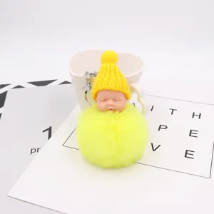 Nahaufnahme des süßen schlafenden Baby-Plüschpuppen-Schlüsselanhängers mit gelber Mütze.
