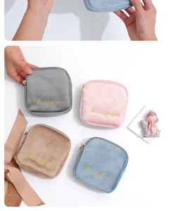 Velvet cosmetic pouch detail view, soft fabric texture with delicate zipper and embroidery.