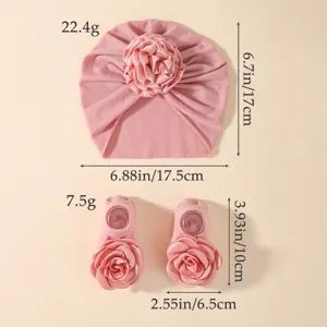 Vue détaillée montrant les dimensions du joli bonnet et des chaussettes à fleurs pour bébé.