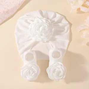 Vue rapprochée détaillée de l'élégant ensemble chapeau et chaussettes de bébé blanc floral.