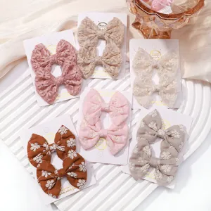 Detailed display of colorful embroidered floral butterfly fabric hair clips for kids