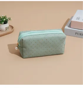 Green corduroy cosmetic bag detail, gold glitter polka dots and cute pearl zipper pull design.