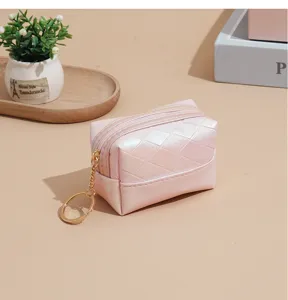 Detail view of a pink iridescent quilted mini coin purse with gold zipper and keychain ring.