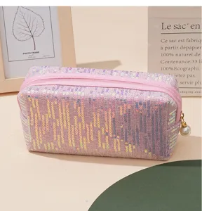 Rosa Pailletten Kosmetiktasche Detail mit glitzerndem Stoff, Reißverschluss und Perlenanhänger.