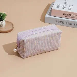 Purple tweed cosmetic bag with pearl zipper pull, stylish storage pouch for travel daily.