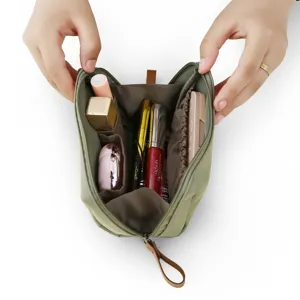 Tragbare grüne Kosmetiktasche mit Fächern für die Aufbewahrung von Make-up und Reisen.
