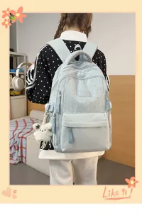 Nahaufnahme eines hellblauen Schülerrucksacks mit Sternenmuster und Plüsch-Anhänger