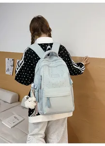 Detailansicht der Rückseite eines hellblauen Rucksacks mit Sternmuster in einem Zimmer