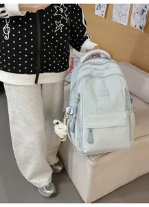 Nahaufnahme eines hellblauen Rucksacks mit Sternmuster und Plüschschaf-Anhänger.