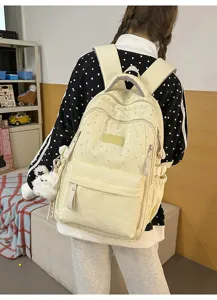 Rückansicht eines cremefarbenen Schulrucksacks mit Sternenmuster und Plüschanhänger