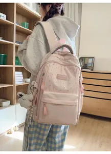 Rosa Rucksack mit Sternenmuster und süßem Plüsch-Anhänger an einem weiblichen Modell
