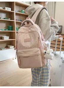 Detailansicht eines rosa Rucksacks mit Sternenmuster und niedlichem weißen Bärenanhänger