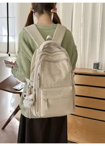 Stilvoller cremefarbener Rucksack mit Sternenmuster und Plüschtier-Anhänger am Model