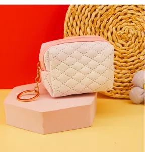 Close-up detail of the mini quilted coin purse showing the stitching, texture and keyring.