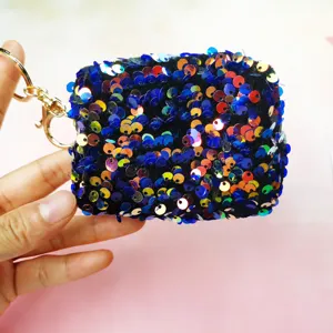 Close-up detail of a mini sequin coin purse with colorful sequins and a gold keychain.