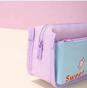 Close-up detail of the pastel purple and blue canvas pencil case showing the cute candy design.